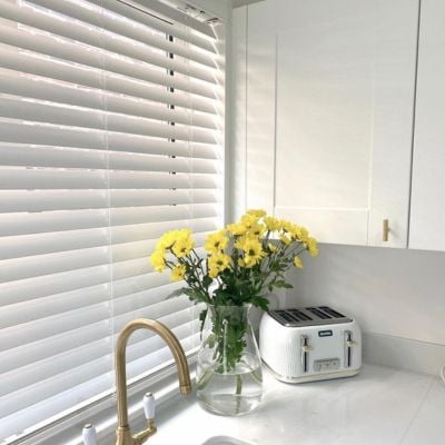 White wooden Venetian blinds with white decorative tapes.