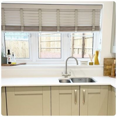 taupe coloured wooden blinds in a kitchen demonstrating cord safety clip in use 