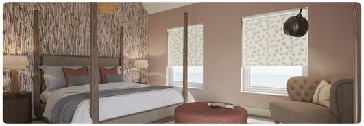 Dainty floral patterned cream blackout roller blinds in bedroom windows.