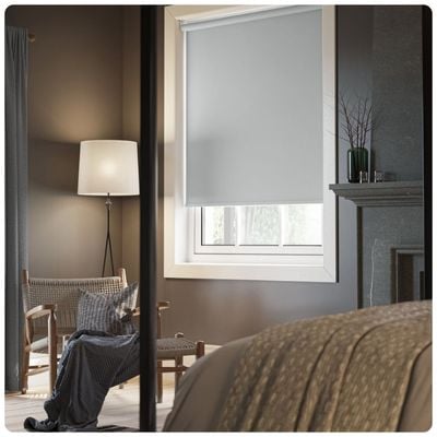 blackout grey blue roller blind in a bedroom window 