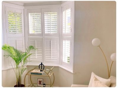 White wooden blinds in a dark grey panelled dining room 