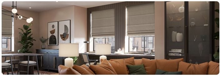 Green roller blinds with a floral pattern over large kitchen windows in a modern open plan kitchen