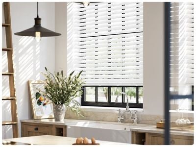 Beige panelled living room with white wooden venetian blinds with tapes. 