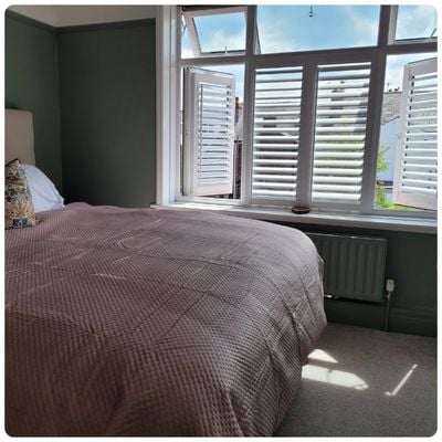 White no drill perfect fit shutters in a bedroom window 