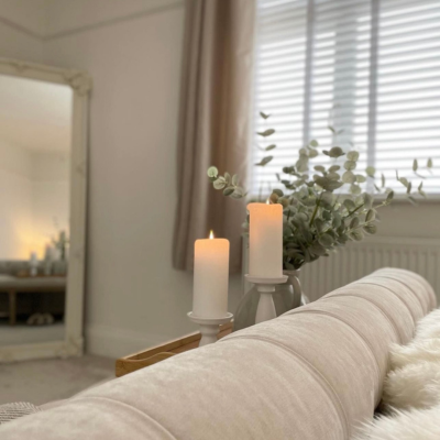 Neutral living room with candles and soft furnishings.