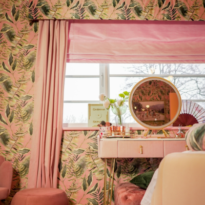 Maximalist pink and green bedroom with matching pink blinds and curtains.