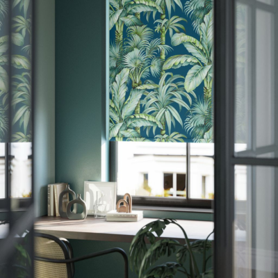 A green, patterned roller blind with a tropical, leaf print.