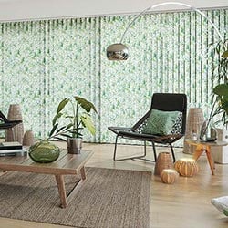 A green, multicoloured Vertical blind is shown in a modern room, covering a large glass window.