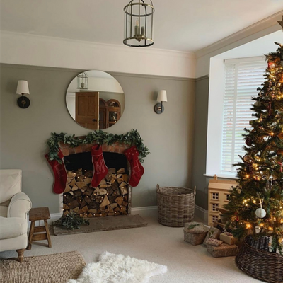 Traditional red and gold Christmas decorations in a sage green living room.