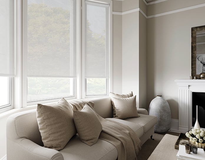 A living room with a grey voile roller blind