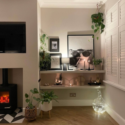 Modern living room with shelving and white shutters. 
