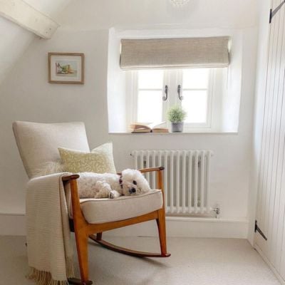 A grey and beige bedroom with a grey roman blind