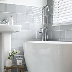 Grey bathroom with white wooden blind in the window