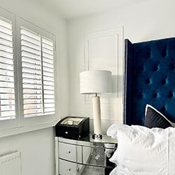 minimilistic bedroom with white shutters in the window