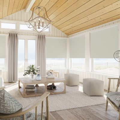 Beige free-hanging pleated blinds fitted to a neutral conservatory 