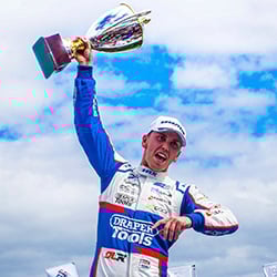 Dan Lloyd holding up his BTCC trophy