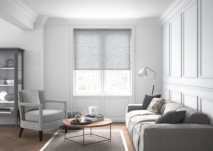 A spotty black and white roller blind in a neutral living room