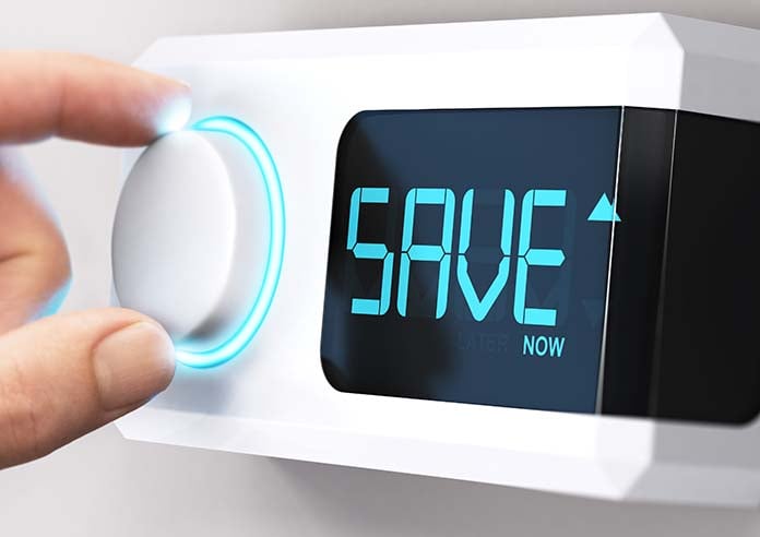 A hand altering a thermostat