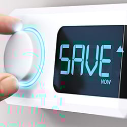 A hand altering a thermostat