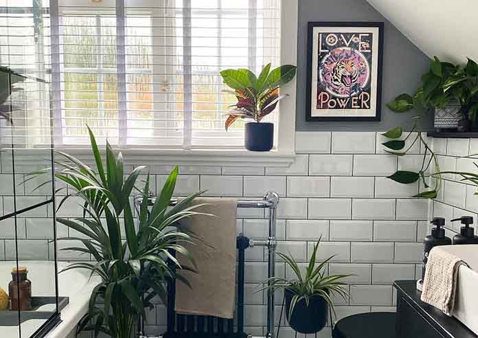 A taped white wooden blind in a botanical style bathroom