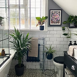 A taped white wooden blind in a botanical style bathroom