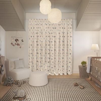 Soft cream curtains with a hot air balloon design in a neutral nursery room 