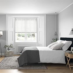 A bedroom image with a ecowood deluxe pure white wooden blind in the window