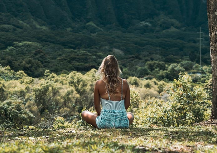 A woman meditating on grassland