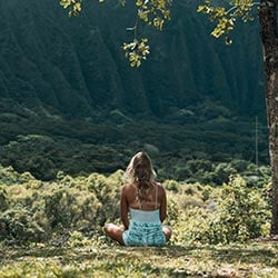 A woman meditating on grassland