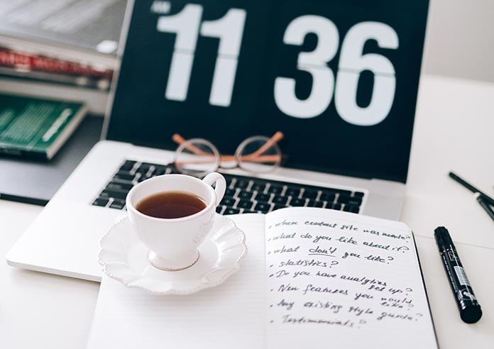Coffee and a journal on a laptop