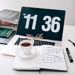 Coffee and a journal on a laptop