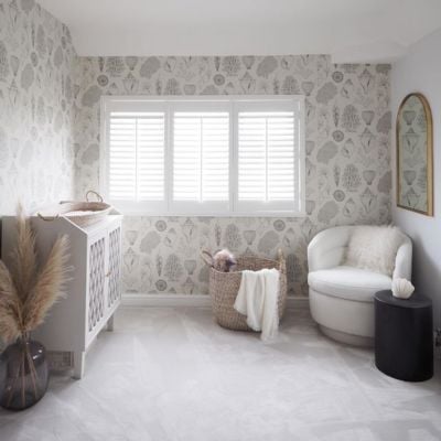 White wooden shutter blinds in a neutral nursery room with botanical wallpaper 
