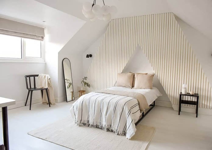 A beautiful neutral coloured bedroom with striped feature wall