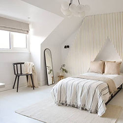 A beautiful neutral coloured bedroom with striped feature wall