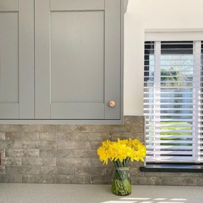 White, taped wooden blinds in a kitchen window