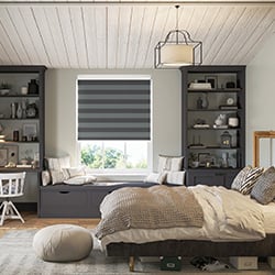 A striped grey roller blind is shown in a bedroom, decorated in a teen-style look.