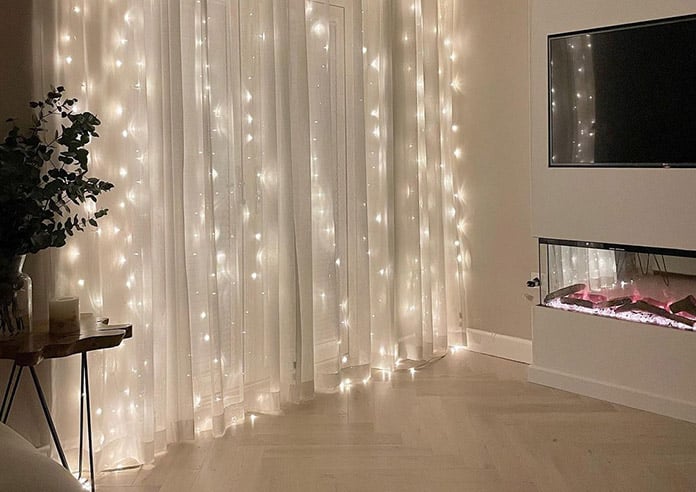 A mix of fairy lights and curtains are a perfect match.