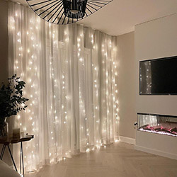A mix of fairy lights and curtains are a perfect match.