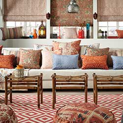 The room is decorated with various Moroccan-styled upholstery, throws and blinds. Each fabric is different and the scheme is mix of texture and red, orange and brown schemes.