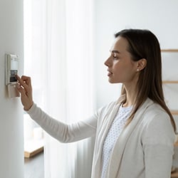 Side view of a young woman using smart home system