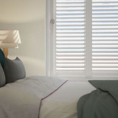 white, no-drill shutters in a modern, neutral bedroom. 